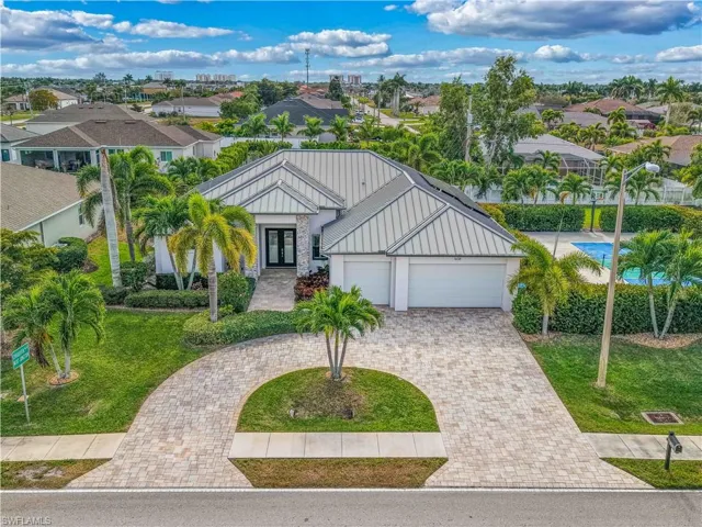 View of front of property with a residential view, french doors, a front lawn, and decorative driveway