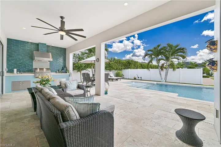 Outdoor pool with an outdoor kitchen, a patio, a fenced backyard, an outdoor hangout area, and outdoor dining area