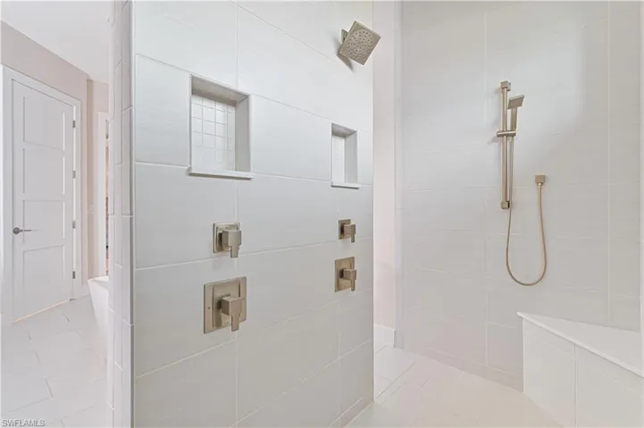 Bathroom featuring a tile shower and light tile patterned floors