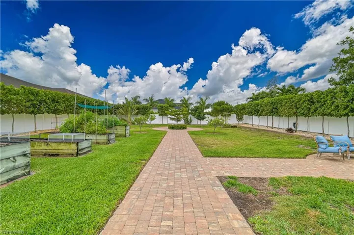 View of home's  fenced backyard, a garden, a patio, and a water view