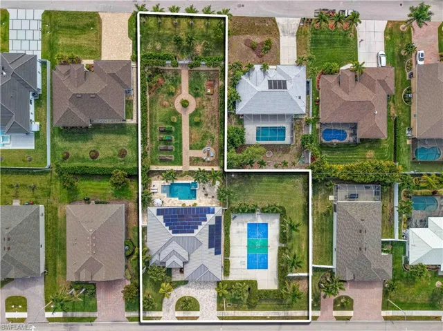 Aerial view of residential area with property parcel outlined and a pool