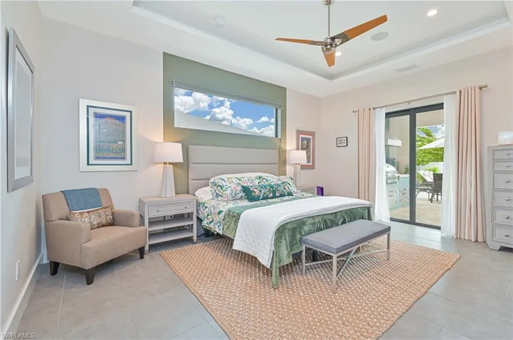 Bedroom with a ceiling fan, a tray ceiling, access to exterior, and recessed lighting