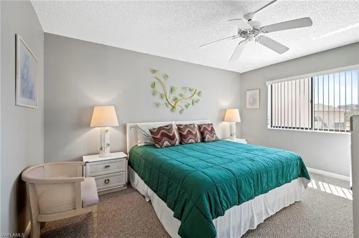 Bedroom featuring carpet flooring, a textured ceiling, and a ceiling fan