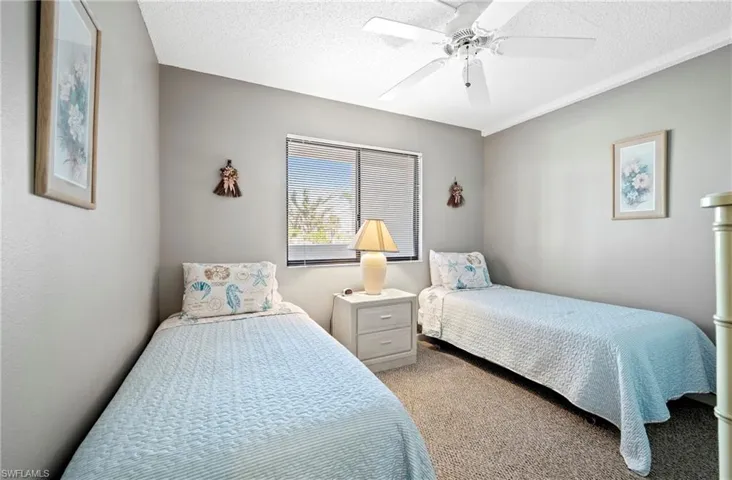 Bedroom featuring a textured ceiling, ceiling fan, and carpet