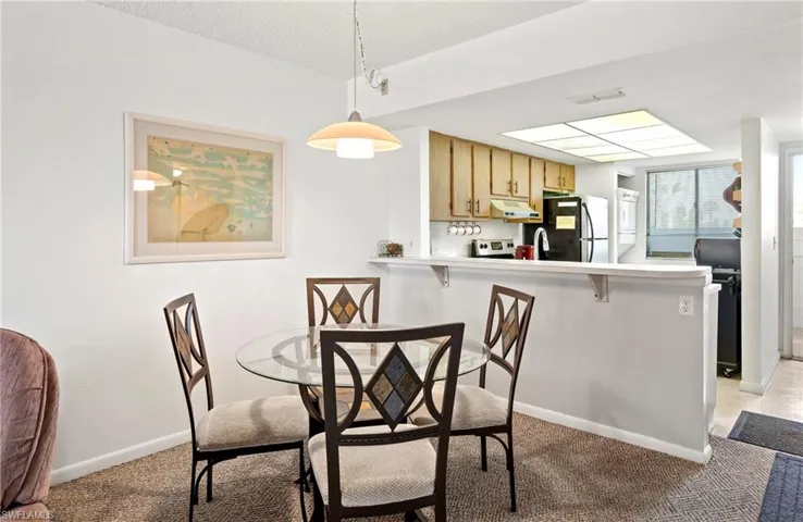 Dining room with light colored carpet and baseboards