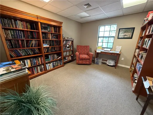 Clubhouse library area with wall of books and a paneled ceiling