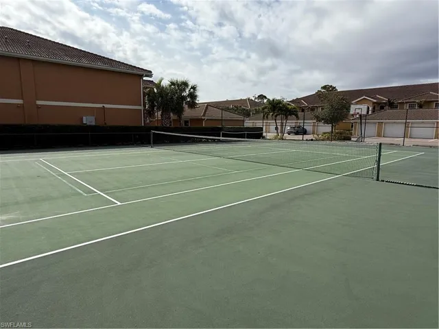 View of tennis court featuring community basketball court and a residential view