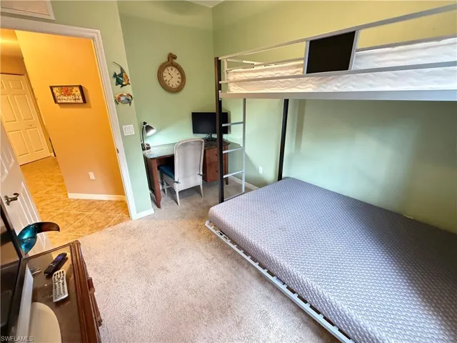 Bedroom with a desk and light colored carpet