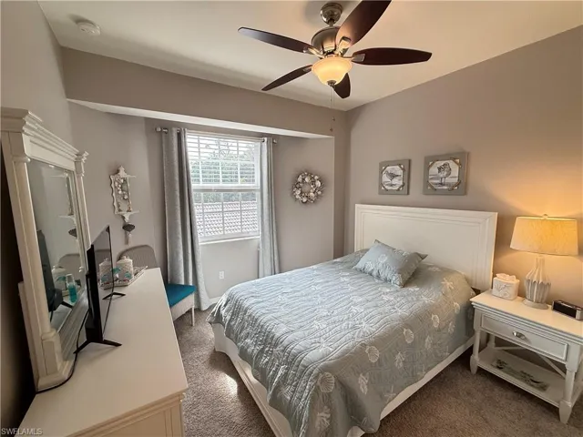 Carpeted bedroom featuring a ceiling fan