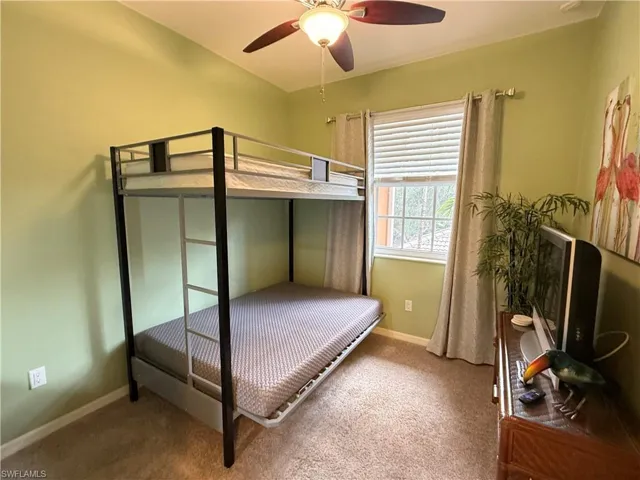 Carpeted bedroom with baseboards and ceiling fan