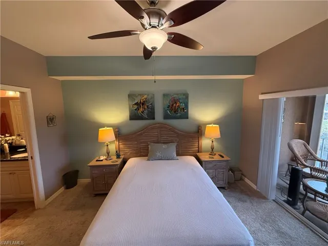 Bedroom with access to exterior, light carpet, ceiling fan, and ensuite bath