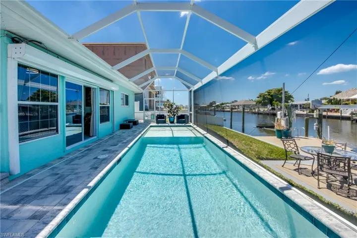 View of swimming pool with a lanai, a patio area, and a water view