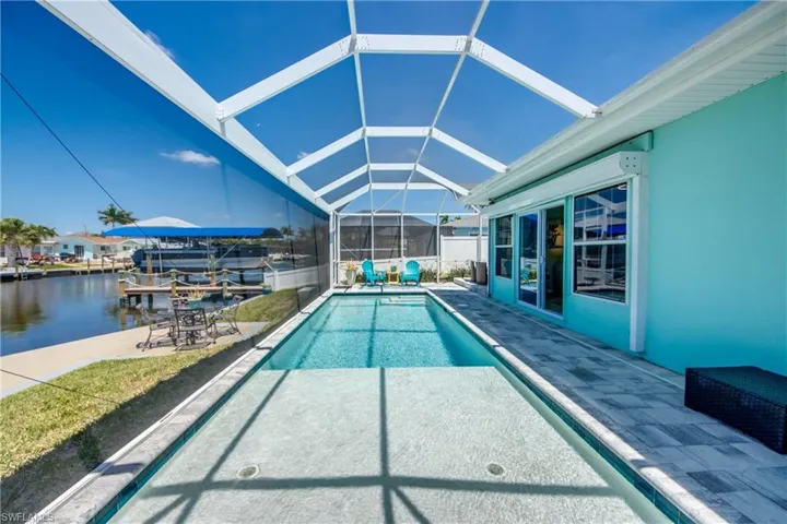 View of swimming pool with a patio, a water view, and a lanai