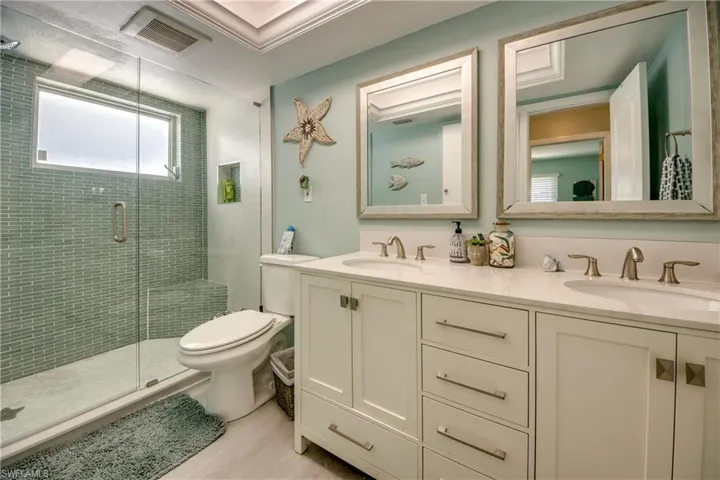 Bathroom featuring vanity, toilet, and an enclosed shower