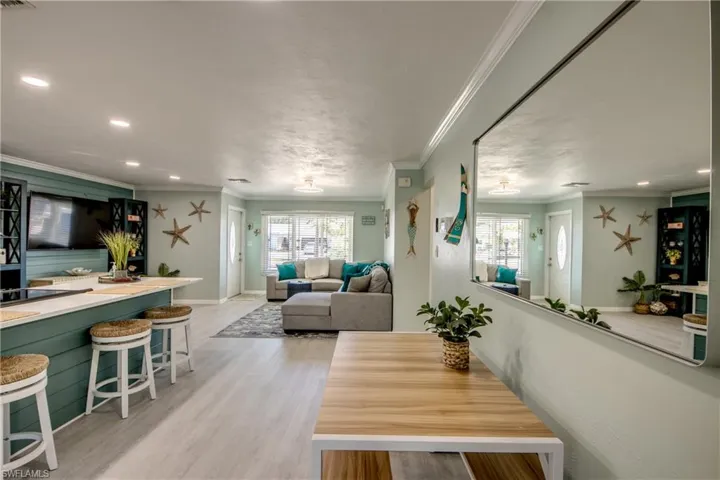 Dining space with light hardwood / wood-style flooring and ornamental molding