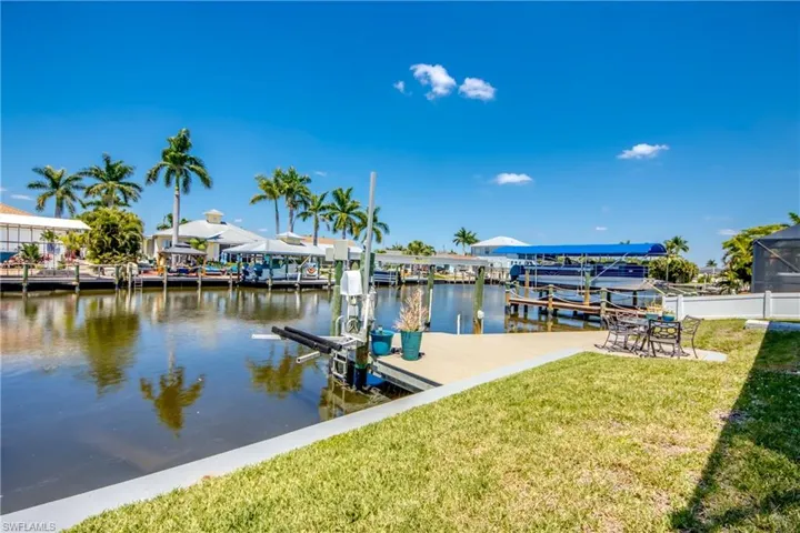 View of dock with a water view and a yard