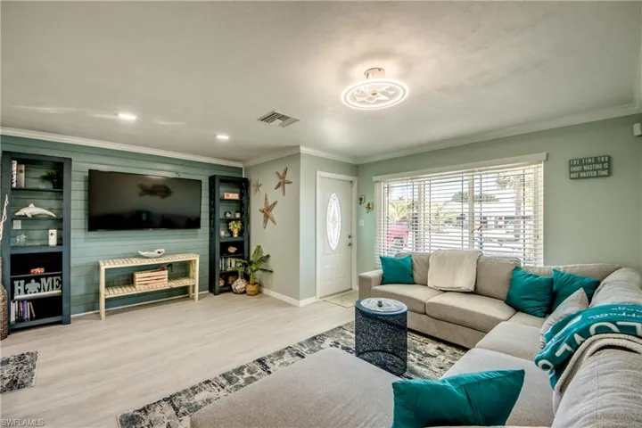 Living room featuring crown molding and light hardwood / wood-style flooring