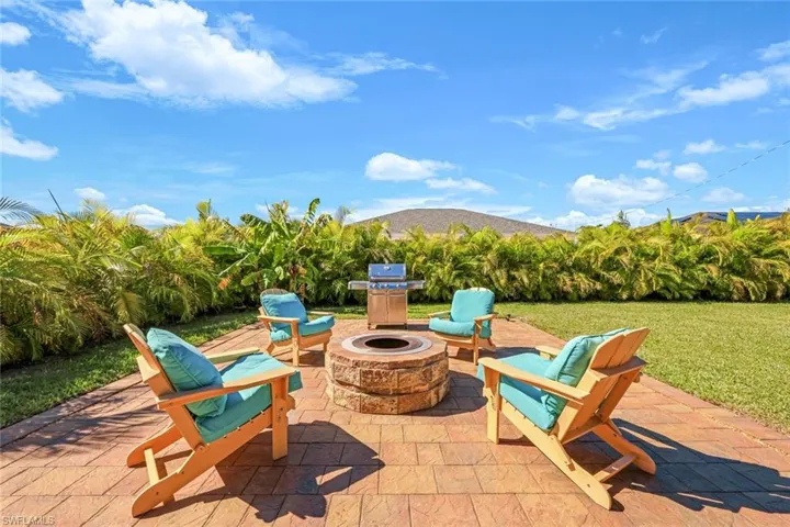 View of patio featuring an outdoor fire pit and a grill
