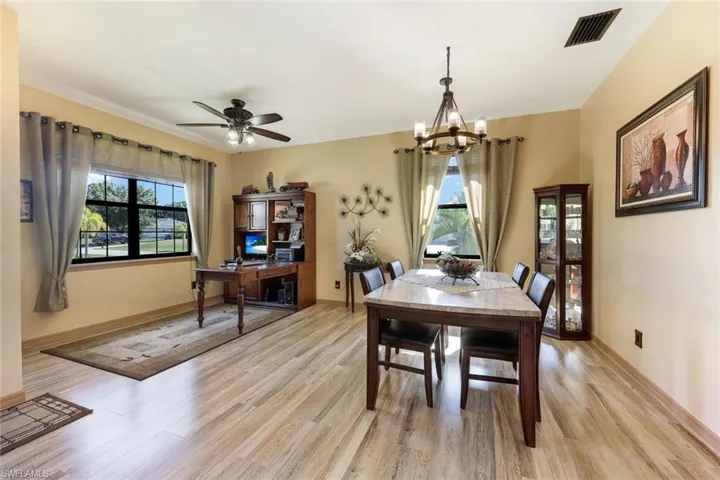 Dining space featuring light wood-type flooring, a chandelier, and a ceiling fan