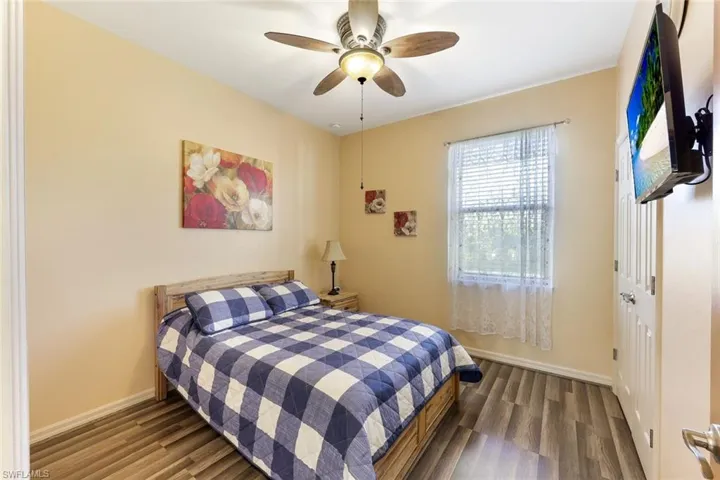 Bedroom with a closet, a ceiling fan, and dark wood-type flooring