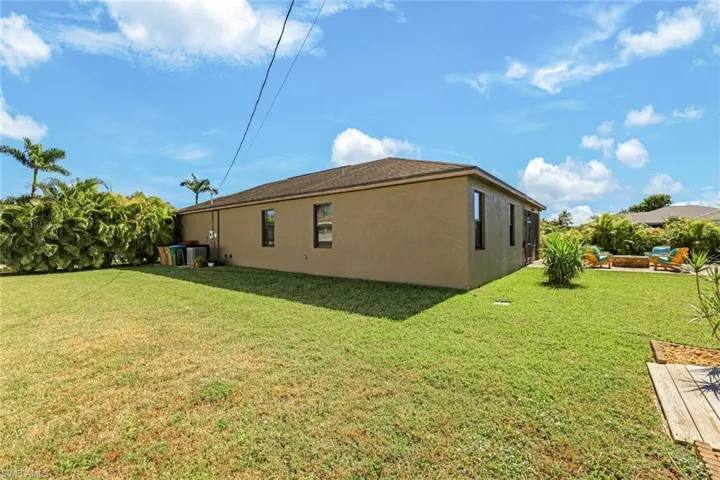 View of property exterior with stucco siding and a lawn