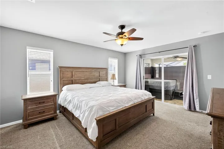 Primary Bedroom featuring light carpet, access to outside, and ceiling fan