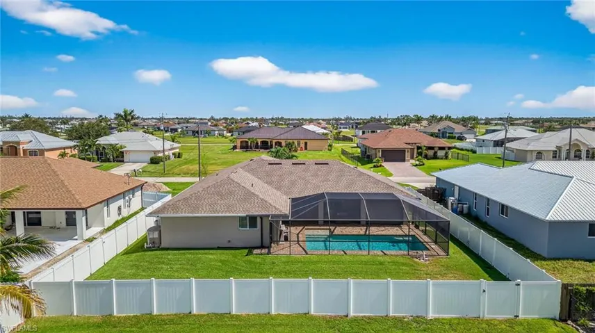 Aerial view of residential area featuring a pool.  Large fenced in backyard.
