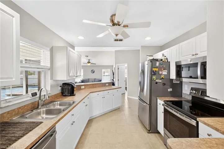 Kitchen featuring stainless steel appliances, a ceiling fan, a peninsula, plenty of natural light, and recessed lighting