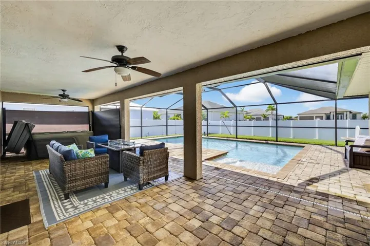 Spacious lanai with outdoor lounging area and spa, a ceiling fan