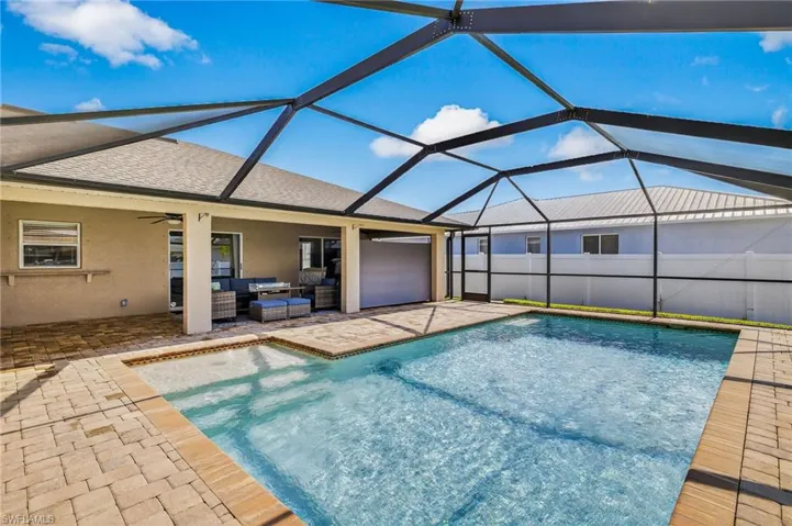 Outdoor pool featuring outdoor lounge area, a patio area, ceiling fan, and glass enclosure