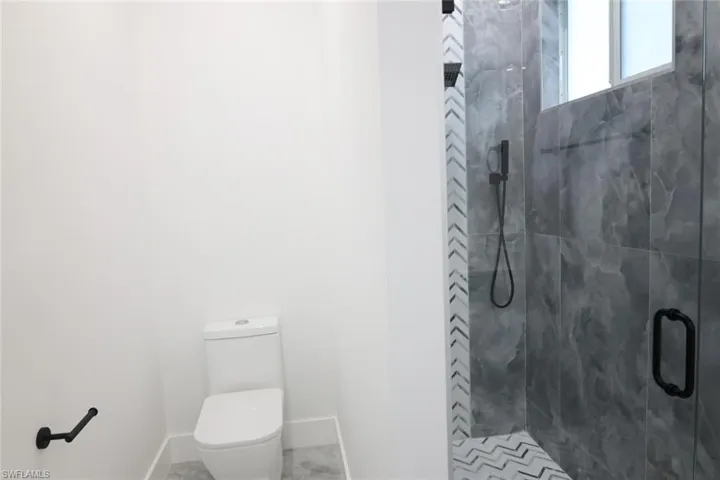 Bathroom featuring a stall shower and toilet