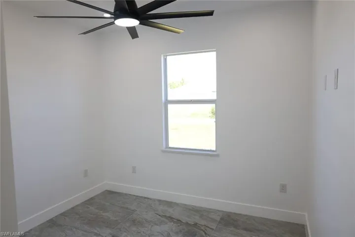 Empty room featuring baseboards and a ceiling fan