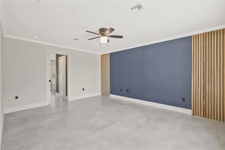 Unfurnished room with ceiling fan and crown molding