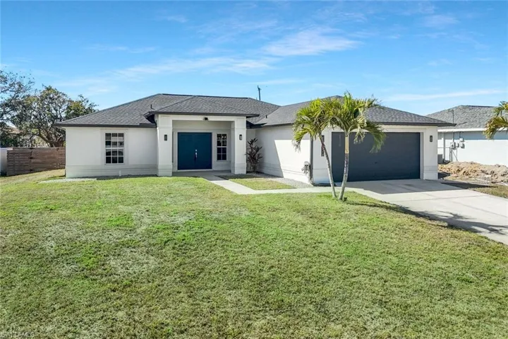 View of front of house with stucco siding, concrete driveway, an attached garage, a front yard, and a shingled roof