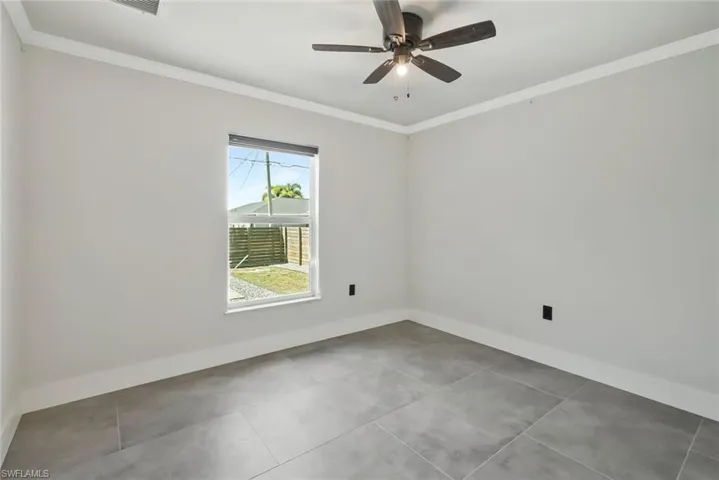 Spare room featuring crown molding and a ceiling fan
