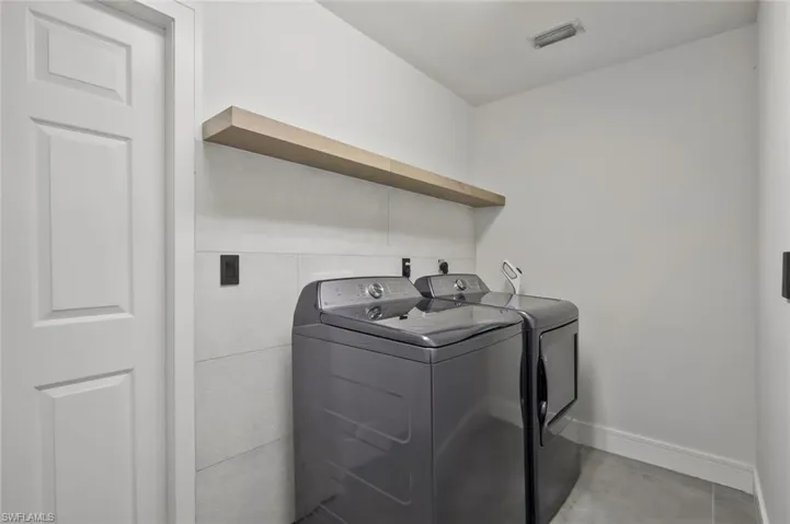 Laundry area featuring separate washer and dryer and baseboards