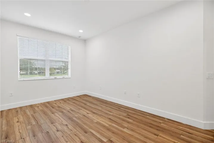 Empty room featuring light wood-type flooring and recessed lighting