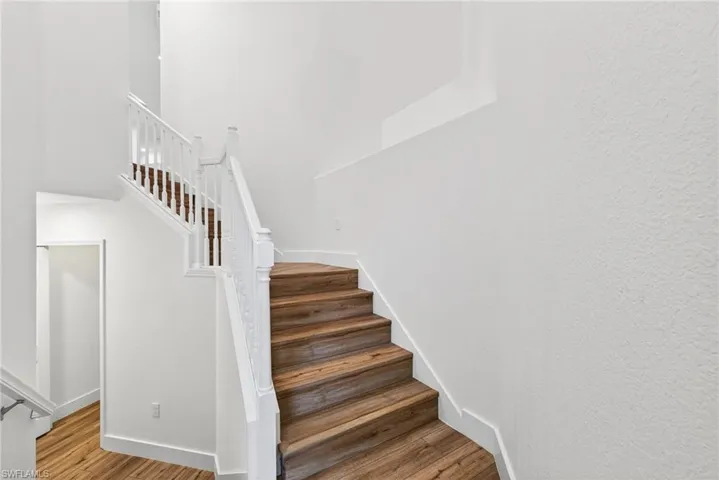 Stairs featuring wood finished floors and baseboards