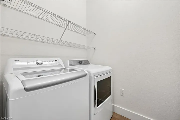 Laundry room with a textured wall and washer and dryer