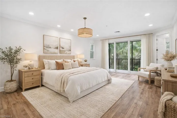 Bedroom with crown molding, access to outside, hardwood / wood-style floors, multiple windows, and recessed lighting
