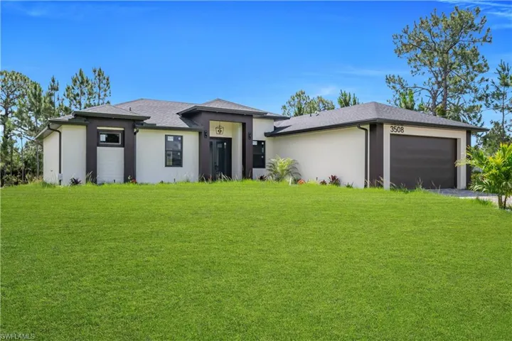 Contemporary single-story residence with a light-colored stucco exterior and dark trim accents