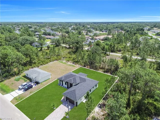 Contemporary single-story residence featuring a dark shingle roof and a spacious, manicured green lawn