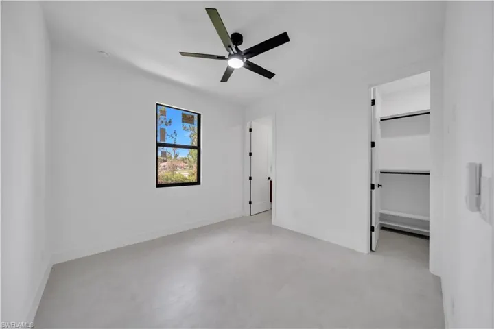 Bright interior space featuring a matte black ceiling fan, recessed lighting, and a window with black trim