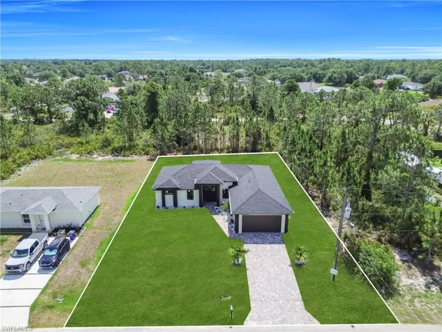 Contemporary single-story residence featuring a dark shingle roof and a paver driveway