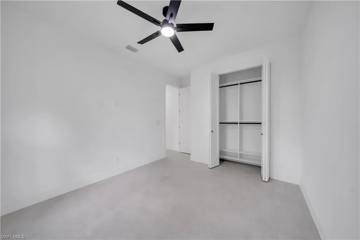 Spacious room featuring light gray tile flooring and white baseboards