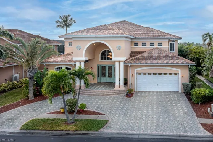 Mediterranean / spanish-style house with french doors, stucco siding, decorative driveway, a tiled roof.