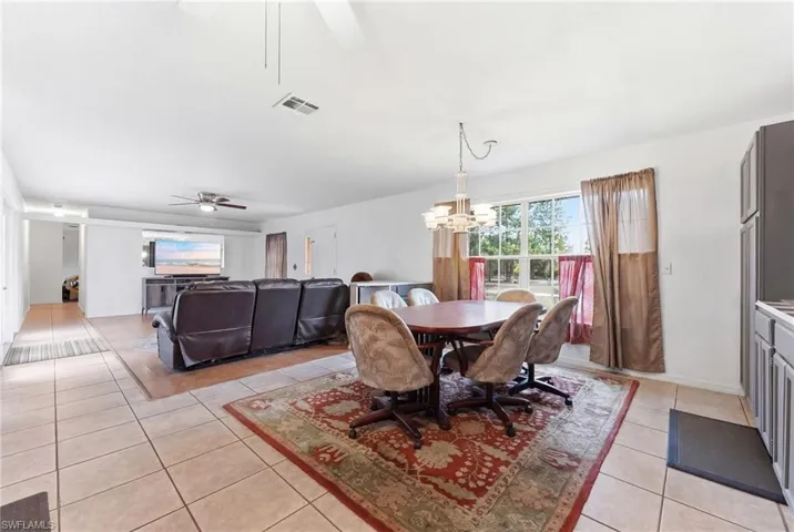Dining room featuring a ceiling fan, hanging lights, and light tile patterned flooring