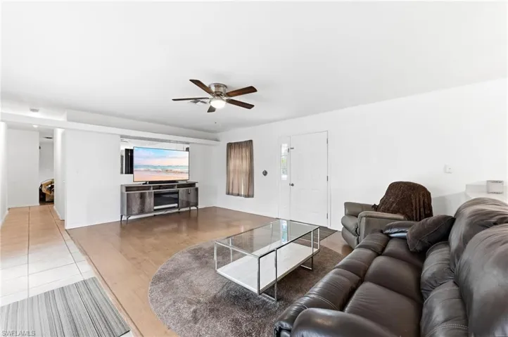 Living room with ceiling fan and light tile patterned floors