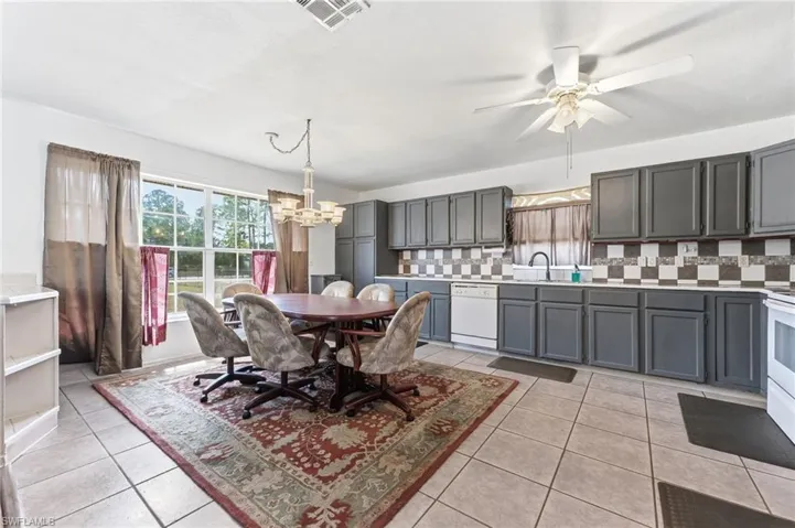 Dining room featuring hanging lights, ceiling fan, and light tile patterned floors
