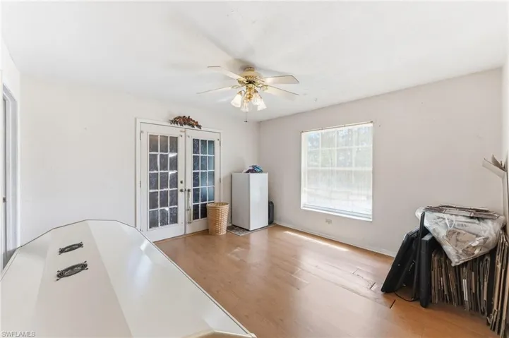 Home office featuring french doors, ceiling fan, and light wood finished floors